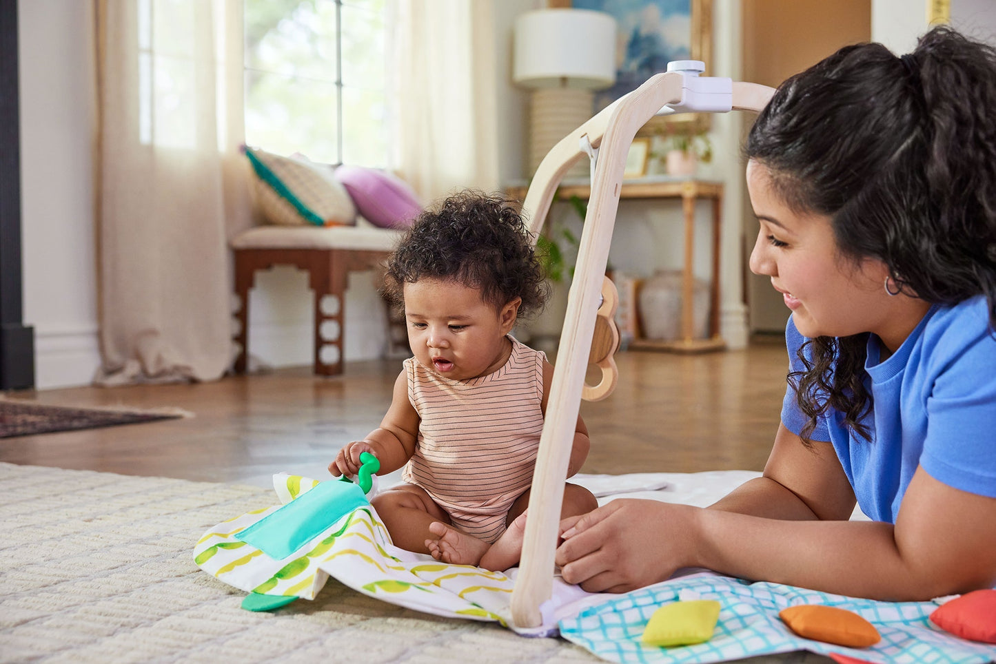 Montessori - aligned play gym for babies with sensory toys - The Nurturing Nook