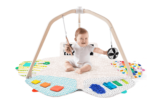 Montessori - aligned play gym for babies with sensory toys - The Nurturing Nook