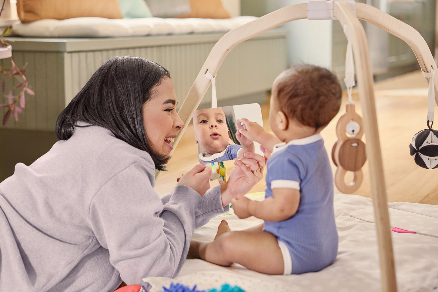 Montessori - aligned play gym for babies with sensory toys - The Nurturing Nook