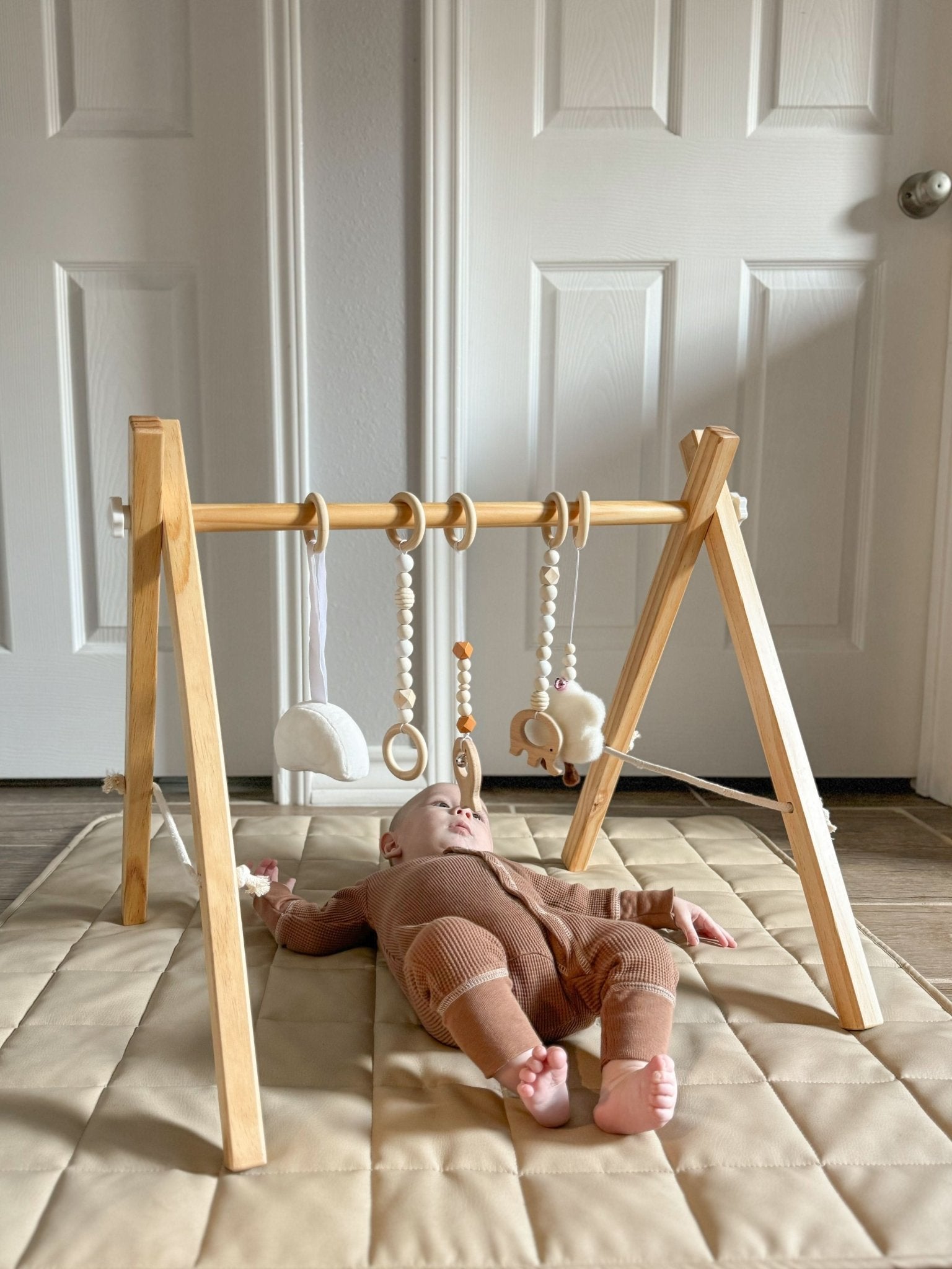 Wooden baby gym for sensory and motor play - The Nurturing Nook